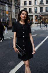 a lady wears a black single-breasted mini dress
